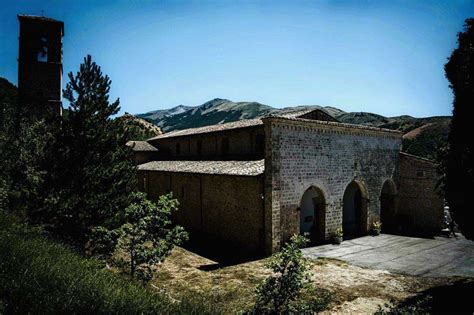 Foto panoramica della Chiesa di San Giovanni Battista di Lucoli, mostrando la sua posizione nel paesaggio abruzzese