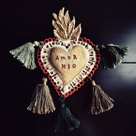dettagli ravvicinati di un ciondolo ex voto a cuore sacro smaltato e traforato