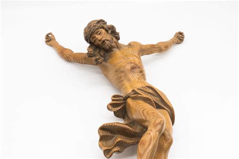 Fotografia artistica di un crocifisso in legno scolpito a mano con dettagli finemente lavorati.