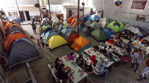 Tenda di un campo di accoglienza migranti, con persone che entrano ed escono liberamente