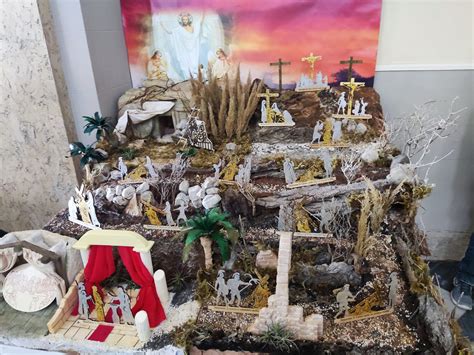 Veduta d'insieme dell'allestimento del presepe pasquale all'interno della chiesa parrocchiale, con il grande crocifisso al centro e l'ambientazione boscosa.