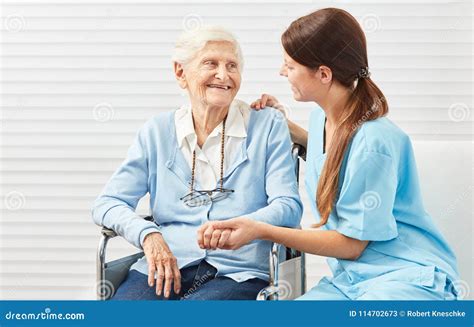 Infermiera che assiste un paziente anziano in una stanza d'ospedale luminosa.