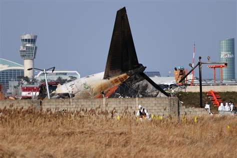 Donna seduta sull'ala di un aereo di linea dopo aver aperto l'uscita di emergenza
