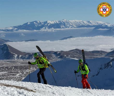 Squadra di soccorso alpino in azione su terreno montano