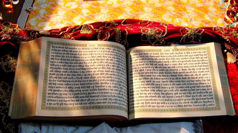 Interno di una casa sikh con una candela accesa e il Guru Granth Sahib in evidenza.