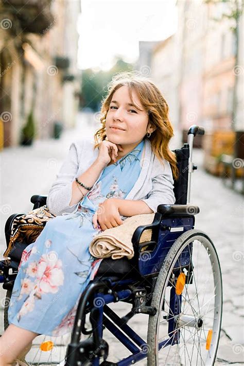 Ritratto di una giovane donna disabile sorridente, in carrozzina, in un contesto comunitario o di fede.