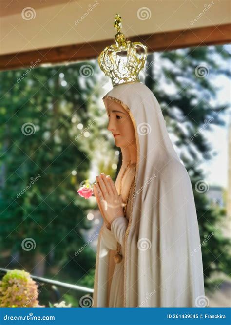 Statua della Madonna di Fatima con corona e mani giunte in preghiera
