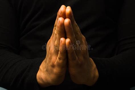 Un'immagine che mostra una persona in preghiera in un luogo di culto, con le mani giunte o il capo chino, trasmettendo un senso di pace e riflessione interiore.