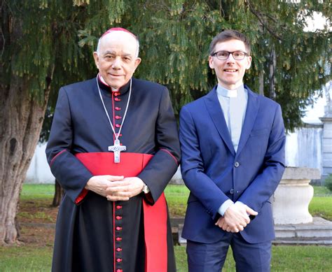 Foto di Don Emanuele Paravano sorridente con sfondo montano della Valcanale