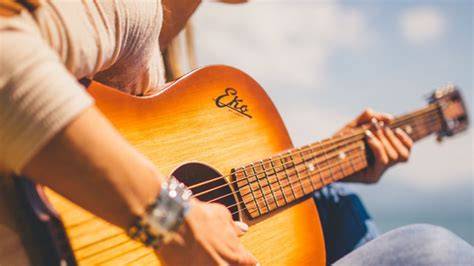 persona che suona la chitarra con tablet per corsi online