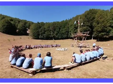 Un'immagine di giovani scout in preghiera durante un campo, con uno sfondo naturale