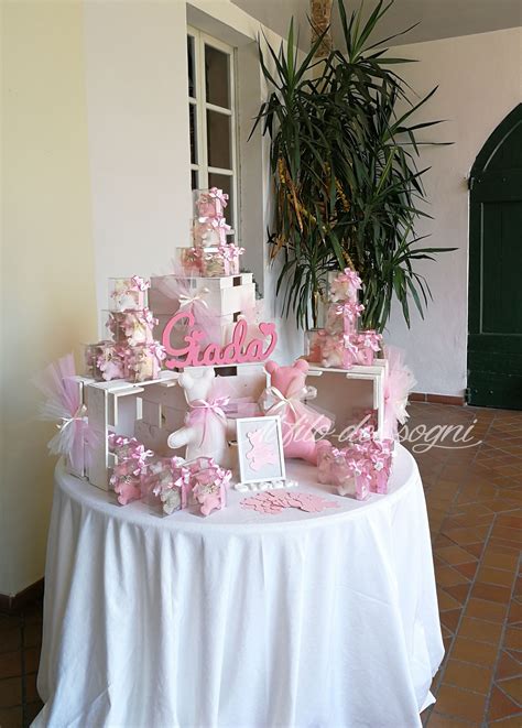Tavolo allestito per battesimo a tema principessa con decorazioni rosa e dorate, fiori e piccole carrozze