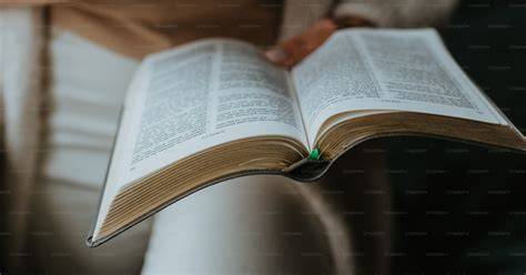 Persona che legge un dizionario o un libro, con parole che fluttuano attorno alla sua testa, simboleggiando l'apprendimento e l'espansione del vocabolario.