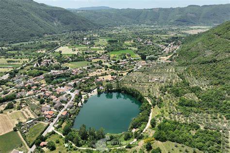 Veduta panoramica del Lago di Paterno con la vegetazione circostante e i ruderi della villa romana in lontananza