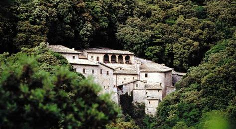 Veduta del chiostro triangolare dell'Eremo delle Carceri con il bosco sullo sfondo