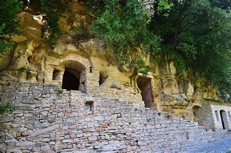 Eremo delle Grotte del Massaccio immerso nella natura, con le sue architetture rupestri e il bosco circostante.