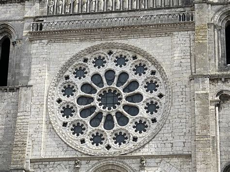 Dettaglio dei rosoni gotici e delle sculture in pietra che adornano la struttura.