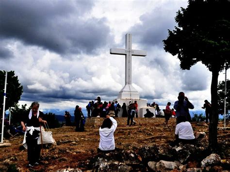 Veduta del Krizevac con la Croce Bianca in cima e pellegrini sul percorso