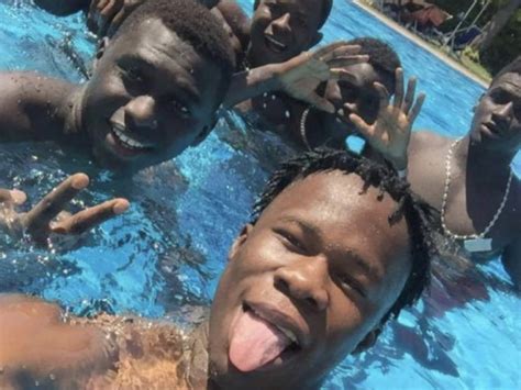Foto di Don Massimo Biancalani con migranti sorridenti in piscina