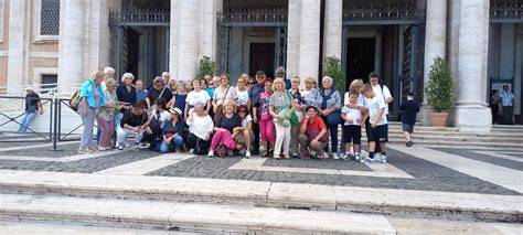 Foto di gruppo di pellegrini davanti a una basilica