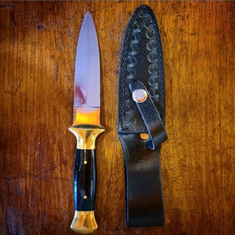 Immagine di un athame con manico nero e un boline con manico bianco