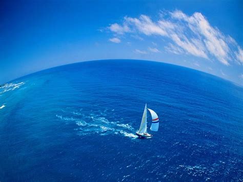 Foto di vele gonfiate dal vento in mare aperto, simbolo di viaggio e fede
