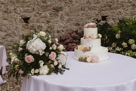 Torta nuziale decorata con fiori e dettagli color lilla e bianco