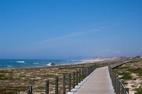 Vista panoramica del Cammino Portoghese della Costa con dune e passerelle di legno.
