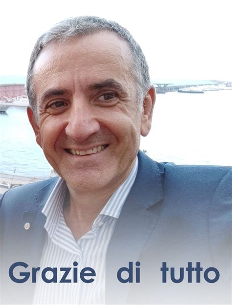 Domenico Panuccio mentre parla con un interlocutore in un ufficio, con un logo della pallavolo sullo sfondo