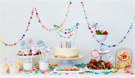 Immagine di una sala parrocchiale allestita per una festa di compleanno con tavoli decorati e giochi