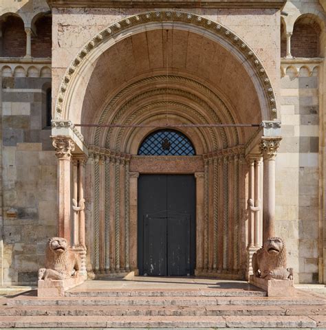 Foto ravvicinata dell'osso di balena appeso sulla Porta Regia del Duomo di Modena, sotto la statua di San Geminiano