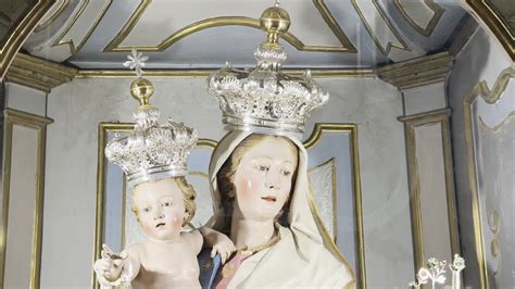 Dettaglio dell'opera d'arte della Madonna della Fontana nella sacrestia, mostrando la Madonna col Bambino e i due arcangeli.