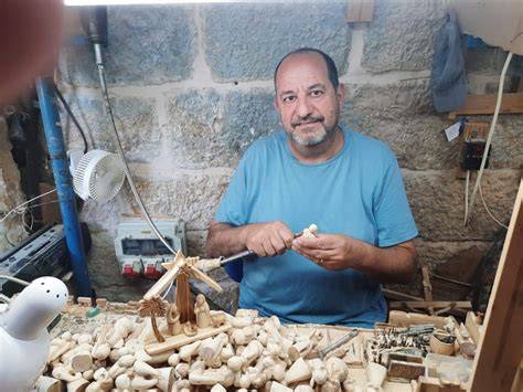 Artigiano di Betlemme che incide la madreperla in una bottega tradizionale