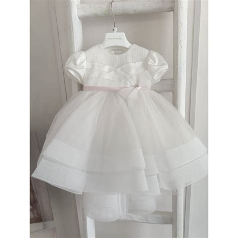 Bambina con abito da battesimo rosa in tulle