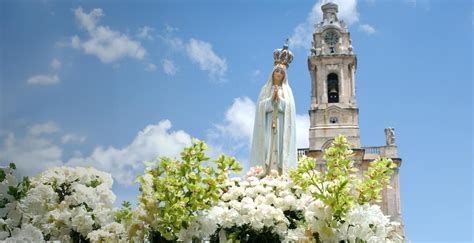 Fedeli in preghiera che depongono bouquet di fiori al Santuario di Nostra Signora di Fatima