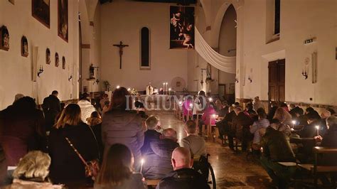 Interno di una chiesa pugliese durante una celebrazione natalizia, con presepe tradizionale