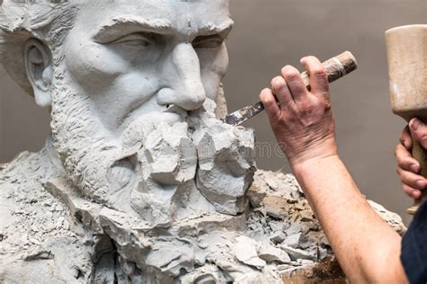 Immagine di uno scultore al lavoro su una statua grezza