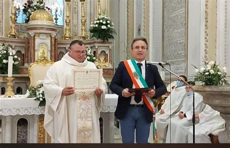 Foto di Don Lillo D'Ugo che riceve la cittadinanza onoraria in una sala gremita
