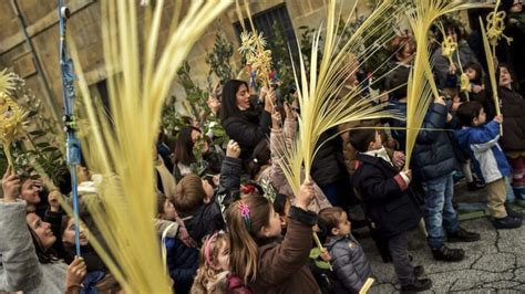 Fedeli in processione con rami benedetti durante la Domenica delle Palme