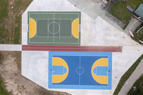 Area esterna della scuola con campi da gioco e pista di salto in lungo rinnovati