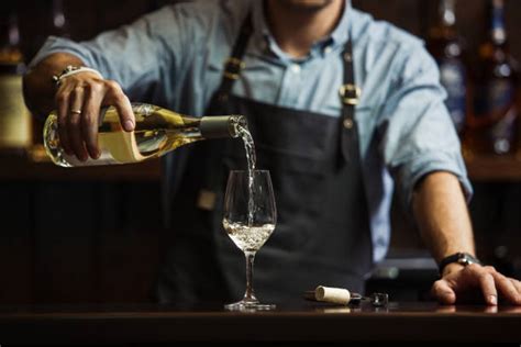 Sommelier che degusta vino o una selezione di bottiglie in una cantina elegante