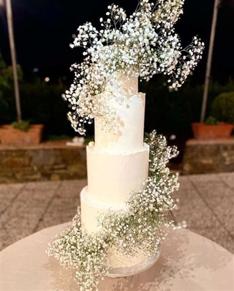 Torta nuziale a più strati decorata con gypsophila e lumini