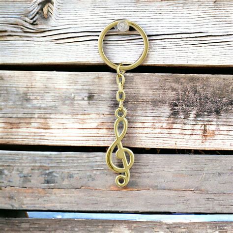 Dettaglio di un portachiavi dorato a forma di chiave di violino.
