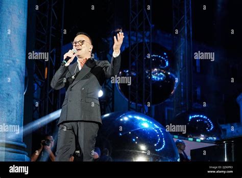 Gigi Proietti mentre si esibisce sul palco con un sorriso iconico