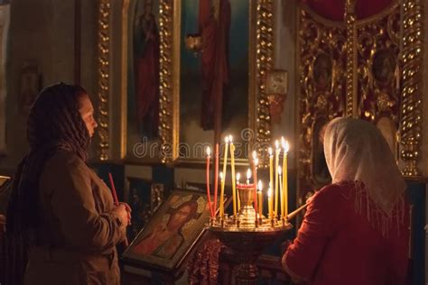 Illustrazione di persone che pregano davanti a lapidi illuminate da candele