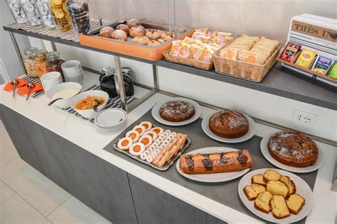 Immagine della sala colazioni dell'Hotel Ariane Lourdes con buffet e posti a sedere