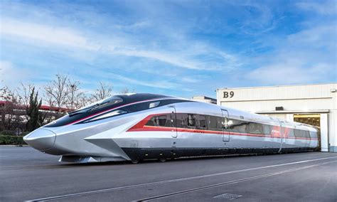 Treno moderno ad alta velocità in movimento attraverso un paesaggio verde