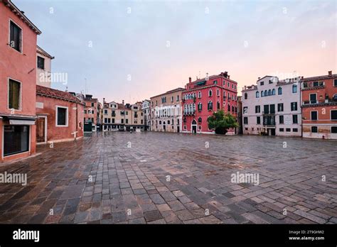 Foto di persone in una piazza vuota, illuminata da luce crepuscolare