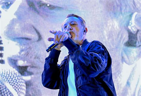 Neffa sul palco, con un microfono e luci soffuse