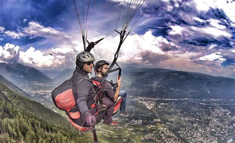 Foto di un parapendio biposto in volo sopra un paesaggio montano
